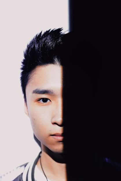 A picture featuring a split image: on one side, a well-known Korean drama actor is shown performing on stage, and on the other side, an American music producer is seen in a studio setting. This split image represents the melding of Korean and American talent in the dorama OST scene.