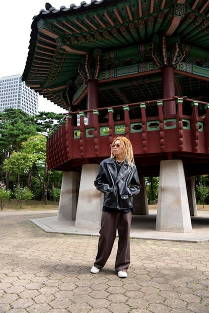 A photograph of Namsan Park in Seoul, with the N Seoul Tower in the background and tourists walking around, enjoying the scenery.